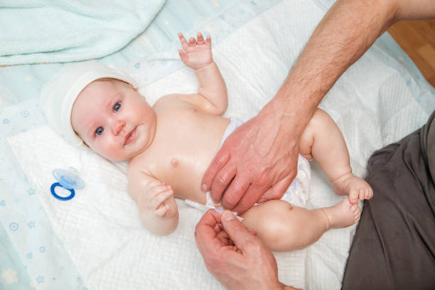 istock Dad puts a diaper on the baby. 942552742