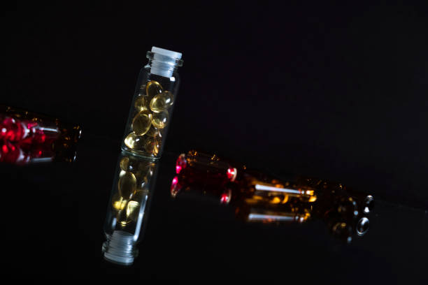 istock Pill bottle and pills in isolated on black concept pharmacy 942559328