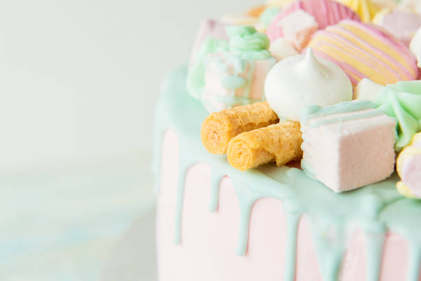 istock Pink cake with cookies, macarons and marshmallows. Selective focus 942559480