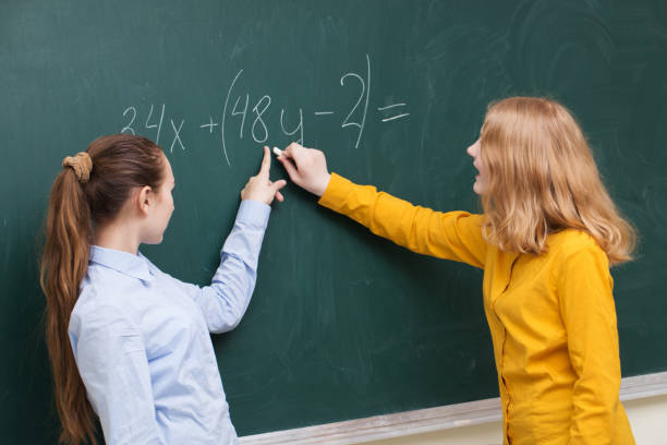 istock Two girls at the blackboard in a mathematics class 942572208