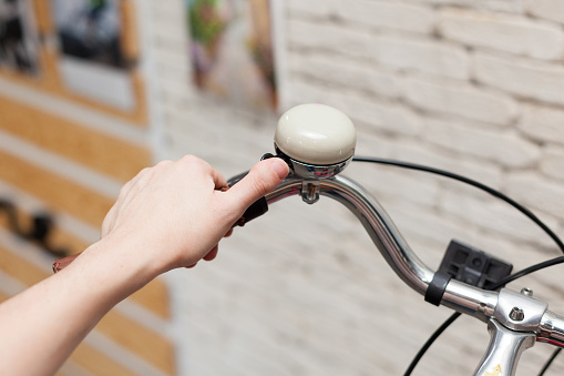 Vintage bicycle rudder. Girl's hand on a bicycle call