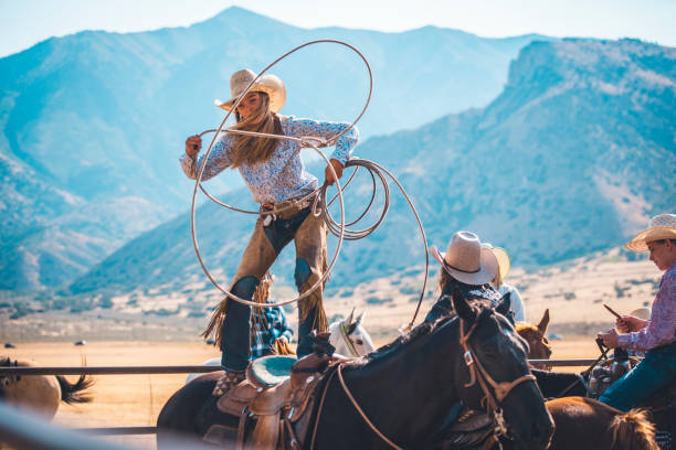 cowgirl mit dem lasso in rodeo arena - rodeo lasso cowboy horse stock-fotos und bilder