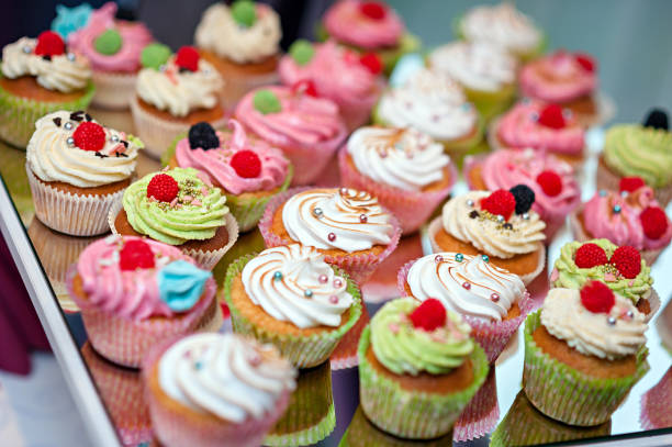 istock Tasty cupcakes on a white wooden table 942581066