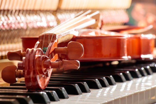 violin on the piano keys with back sunshine light background