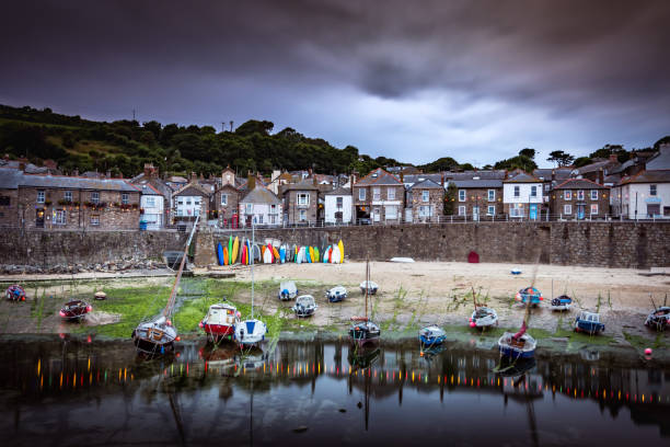 vista delle barche ormeggiate nel pittoresco mousehole harbour vicino a penzance, in cornovaglia - penzance foto e immagini stock