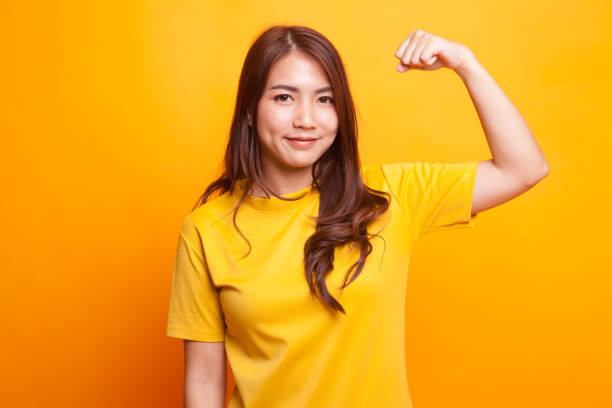 istock Beautiful young Asian woman flex bicep. 942585366