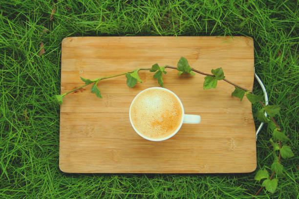 istock Full cup of coffee on green background 942594796