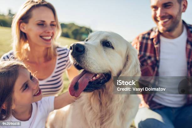 Familia Feliz Con Un Perro Foto de stock y más banco de imágenes de Perro - Perro, Familia, Mascota