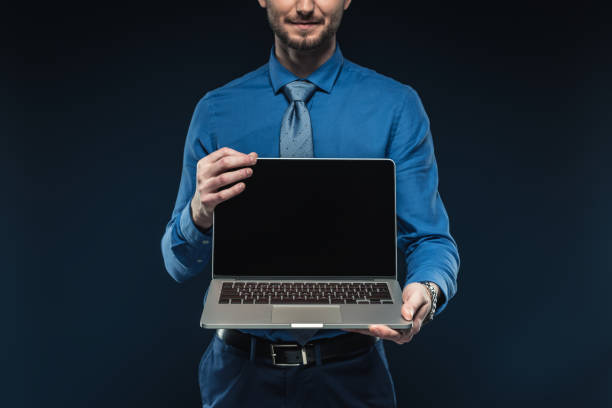 istock Young man presenting laptop with blank screen isolated on blue 942599906