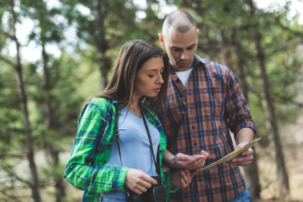 istock Couple in the woods looking map 942603810