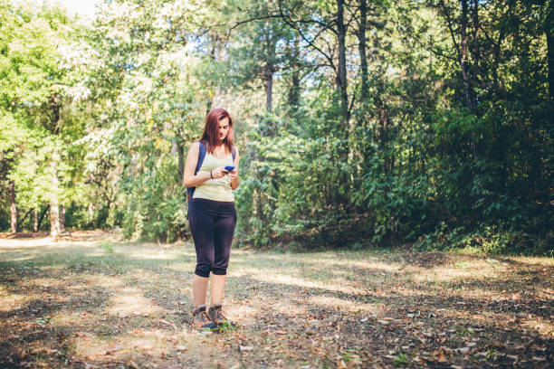 istock Woman using her smartphone while wandering in the forest. 942606820