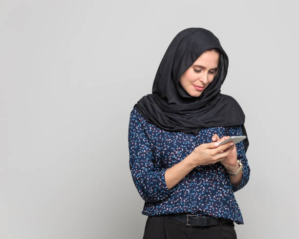 istock Cheerful young muslim woman using smart phone 942606850