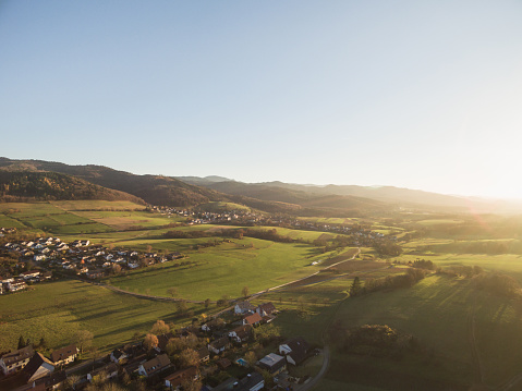 aerial view of rooftops, houses and beautiful green hills with trees at sunlight, Germany
