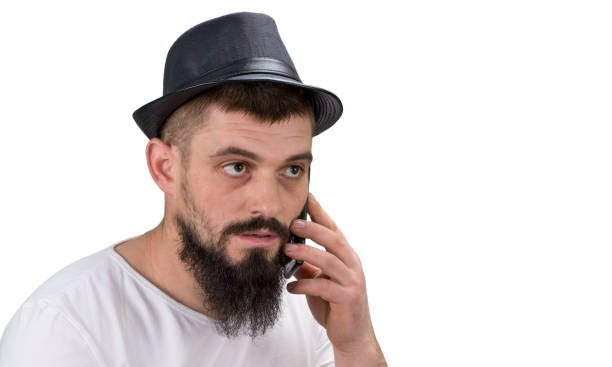 istock Serous bearded  man in hat  talking on the phone isolated on white background with copy space 942607672