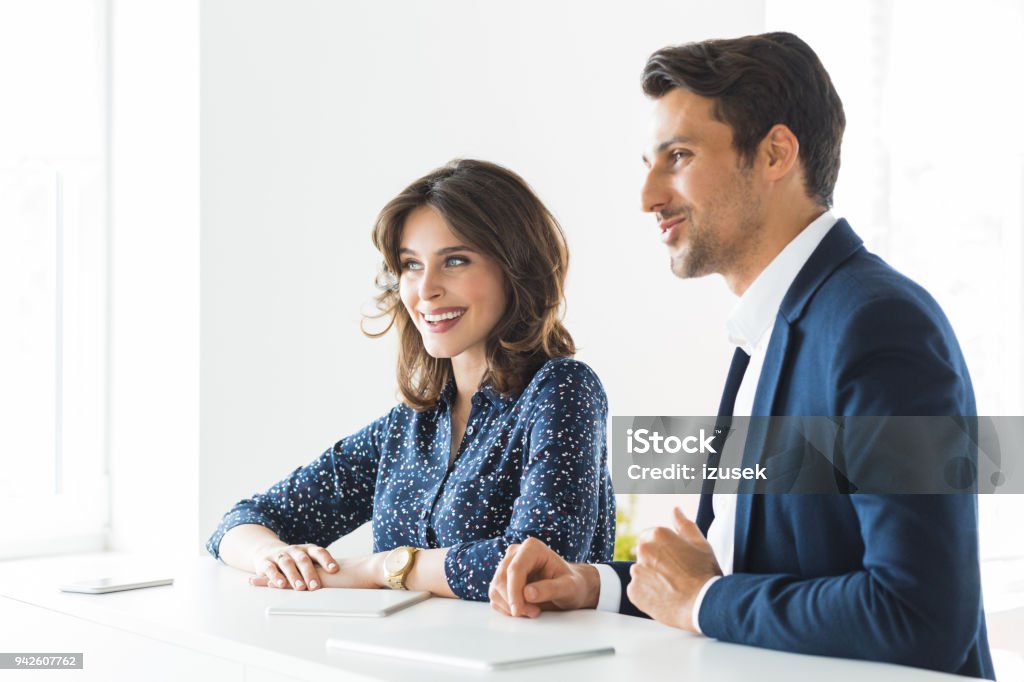 Confident business colleagues together in office Two young businesspeople standing together in office. 20-29 Years Stock Photo