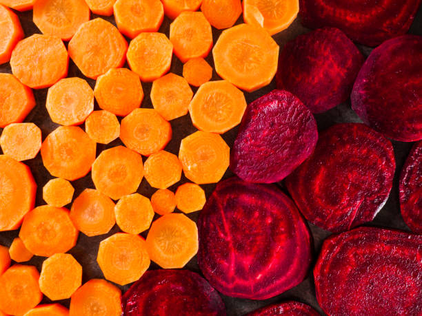 istock Beetroot and carrot slices over dark gray marble background. 942607894