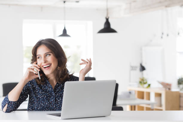istock Beautiful woman talking on phone at office 942607958