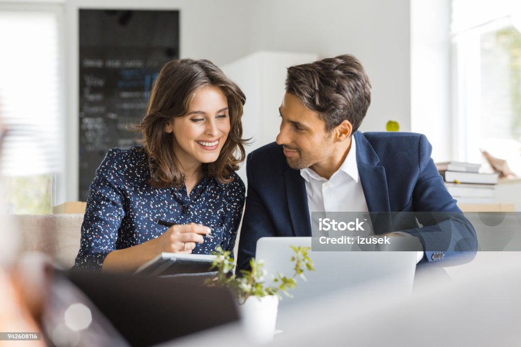 Modern business people working at a cafe Two business colleagues sitting in a cafe and working on laptop. Business couple having a meeting in cafe. Adult Stock Photo