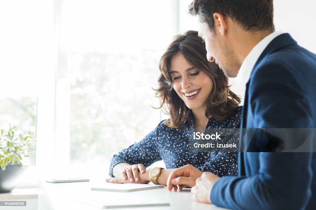 Business couple meeting in office Happy young woman discussing with businessman at workdesk. Business couple meeting in office. Financial Advisor Stock Photo
