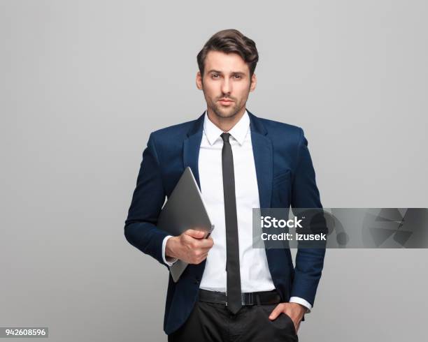 Confident And Handsome Businessman Holding Laptop Stock Photo - Download Image Now - Laptop, Businessman, Standing