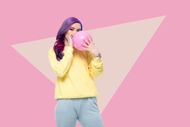 istock beautiful young woman blowing up balloon on creative background 942611922