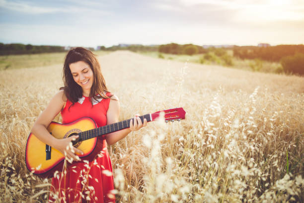 istock Woman plays guitar in a wheat field. 942612326