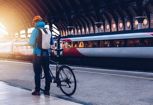 Young man who wearing helmet, is with bicycle on a public transport.