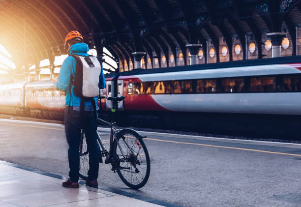 Young man with bicycle on a public transport. Young man who wearing helmet, is with bicycle on a public transport. public transportation stock pictures, royalty-free photos & images