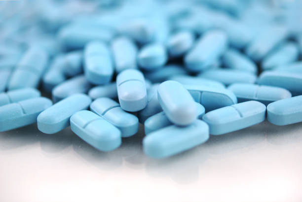 istock Blue round tablets close-up on white background 942615756
