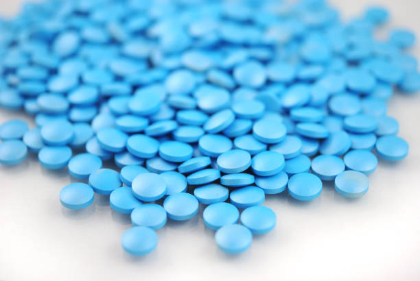 istock Blue round tablets close-up on white background 942615790