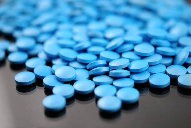 istock Blue round tablets close-up on white background 942615796