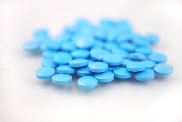 istock Blue round tablets close-up on white background 942615808