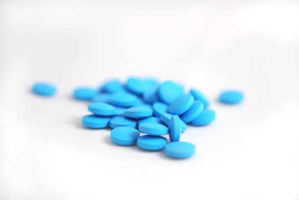 istock Blue round tablets close-up on white background 942615916
