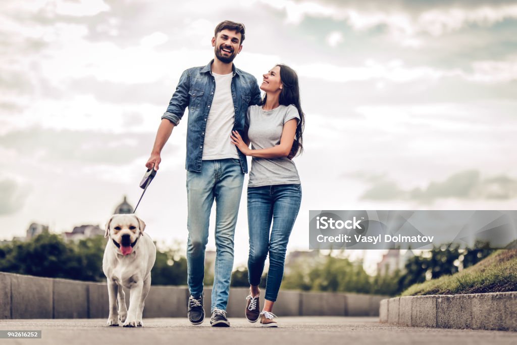 Couple sur une promenade avec le chien - Photo de Marcher libre de droits