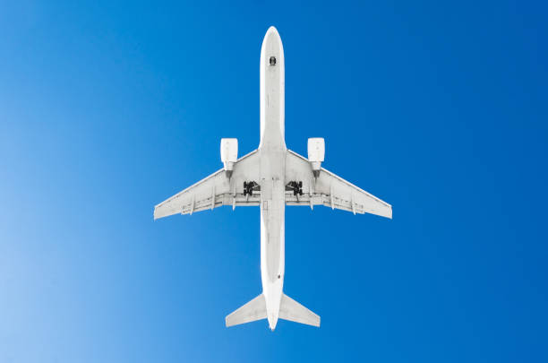 istock Passenger airplane. View exactly from below, white silhouette against the blue sky. 942617816