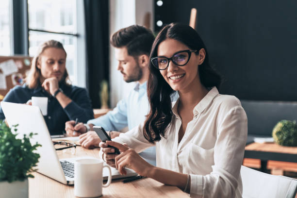 Confident and successful. Young modern colleagues in smart casual wear working while spending time in the office smart casual stock pictures, royalty-free photos & images