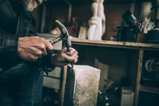 Senior bearded Stonecutter working at his workshop,being concentrated