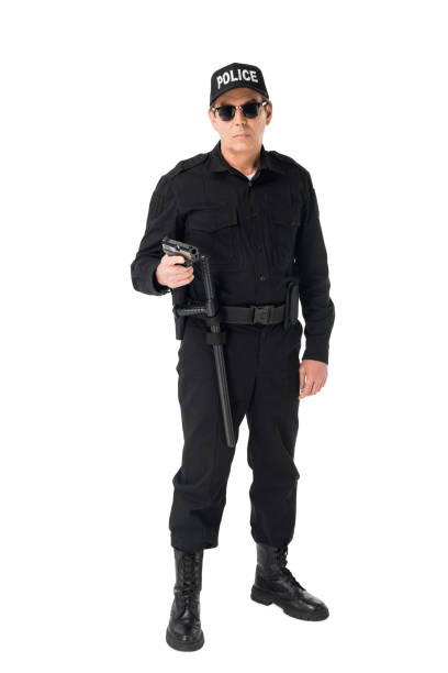 istock Serious policeman in sunglasses holding gun isolated on white 942627006