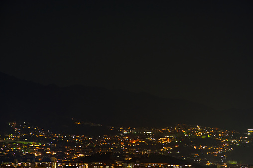 The light in the town in the base in a mountain at night.