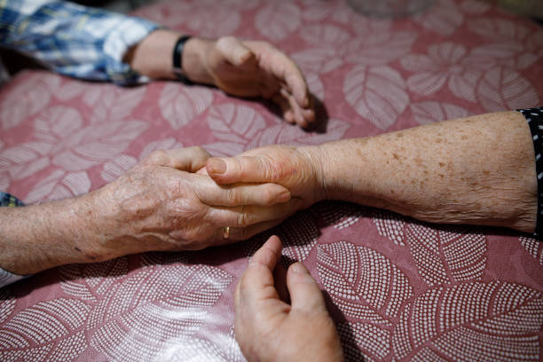 istock Sixty years together.The old couple is holding hands on table 942634858