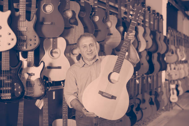 istock Mature man choosing acoustic guitar 942635158