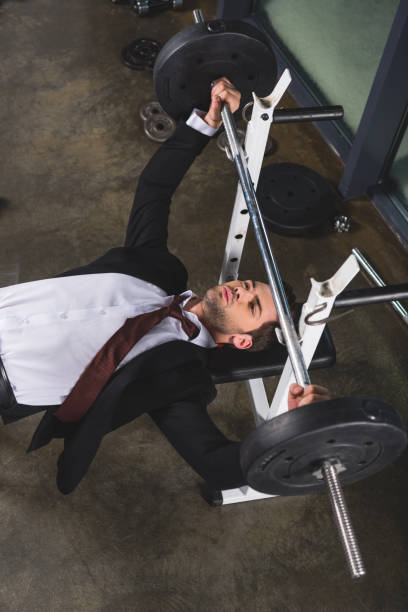 przystojny biznesmen w garniturze szkolenia ze sztangą w siłowni - businessman exercising training muscular build zdjęcia i obrazy z banku zdjęć