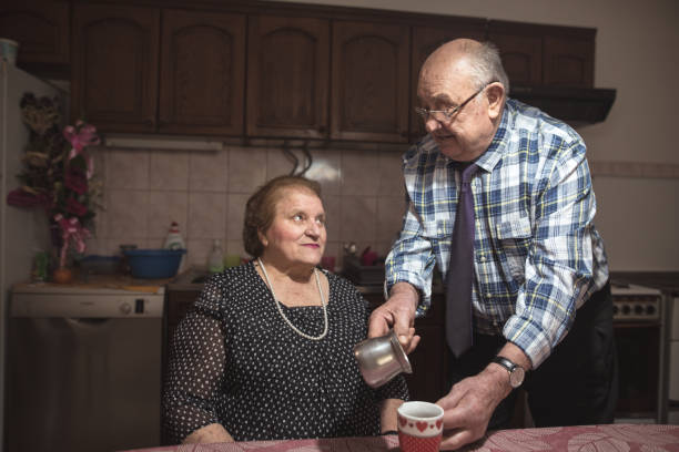 sechzig jahre zusammen. gerne älteres paar im wohnzimmer - overweight smiling senior women 70s stock-fotos und bilder