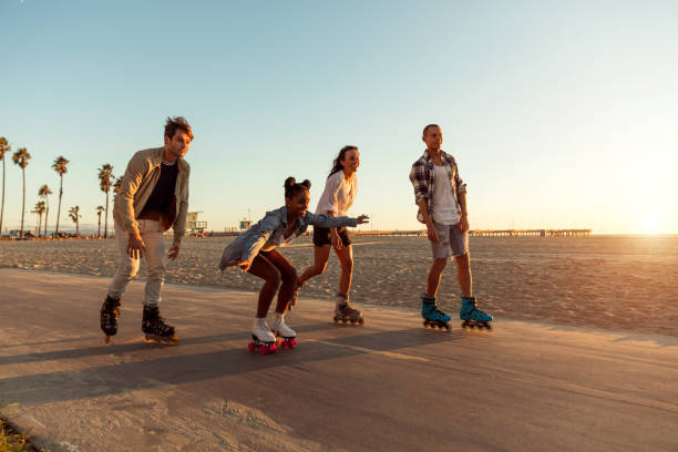 friends roller skating on the boardwalk in venice beach - santa monica promenade - los angeles, usa - santa monica beach imagens e fotografias de stock