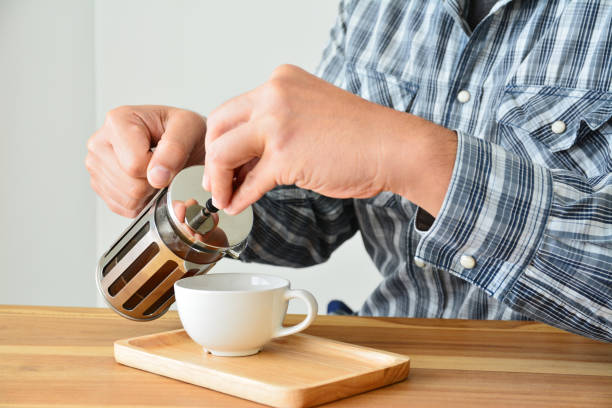 istock Man holding french press coffee pot and white cup 942647476