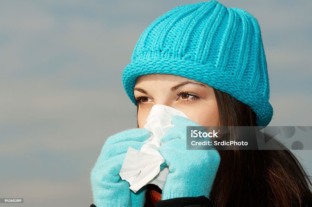 Jovem fêmea sneezing em tecido - Foto de stock de Adulto royalty-free