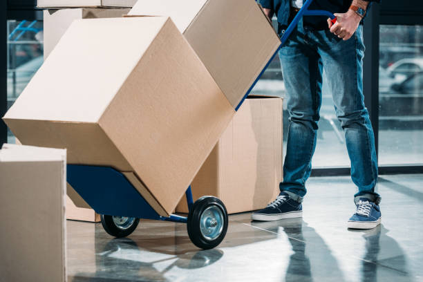 vista de primer plano del repartidor, llevando cajas en el carro - carretilla industrial fotografías e imágenes de stock