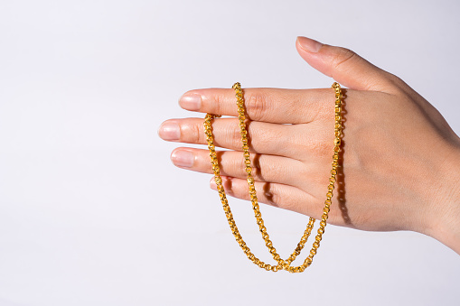 Women have been holding gold necklaces, isolated white background, copy space.
