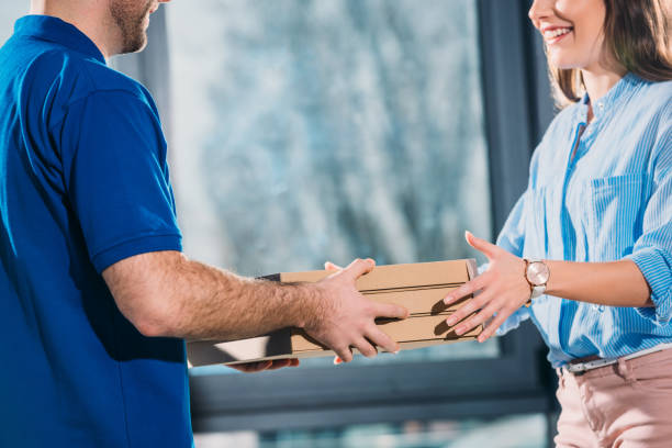 istock Woman receiving pizzas in boxes from delivery man 942669410