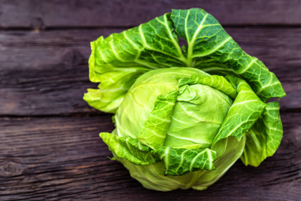 istock Green fresh cabbage head on wooden surface 942669676